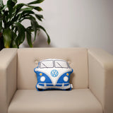 Front view of a blue and white Plush Shaped Cushion, shaped like a Volkswagen VW T1 Camper Bus, featuring a split-windscreen, round headlights, and central emblem, resting on a beige armchair.