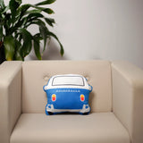 Back view of a blue and white plush Volkswagen T1 Camper Bus shaped cushion, featuring the 'VOLKSWAGEN' text and red and yellow tail lights, resting on a light-coloured armchair.