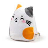 Angled view of a white, orange, and grey cat plush toy, featuring embroidered winking eyes, pink cheeks, and black whiskers. The soft toy has contrasting orange and grey ears, and a visible product label on its side.