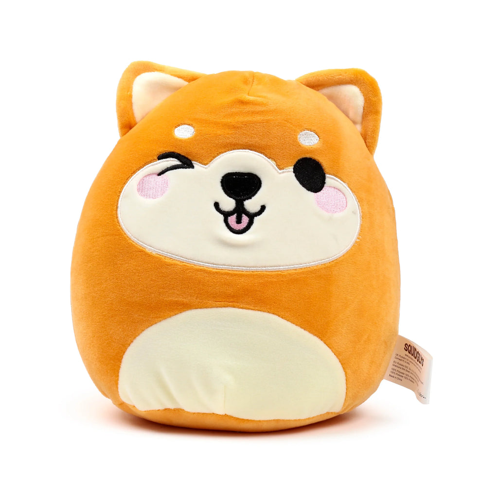 Front view of a soft, round orange and cream Shiba Inu dog plush toy, featuring a winking eye, smiling mouth with pink tongue, and pointed ears.