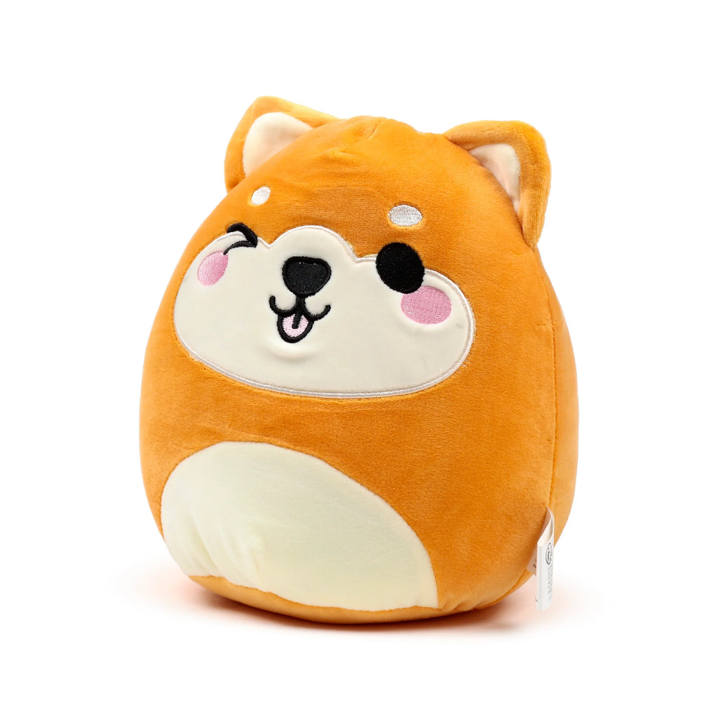 Front view of an orange and cream coloured Squidglys Shuggs Shiba Inu dog plush toy, featuring a winking face, black nose, and pink cheeks.