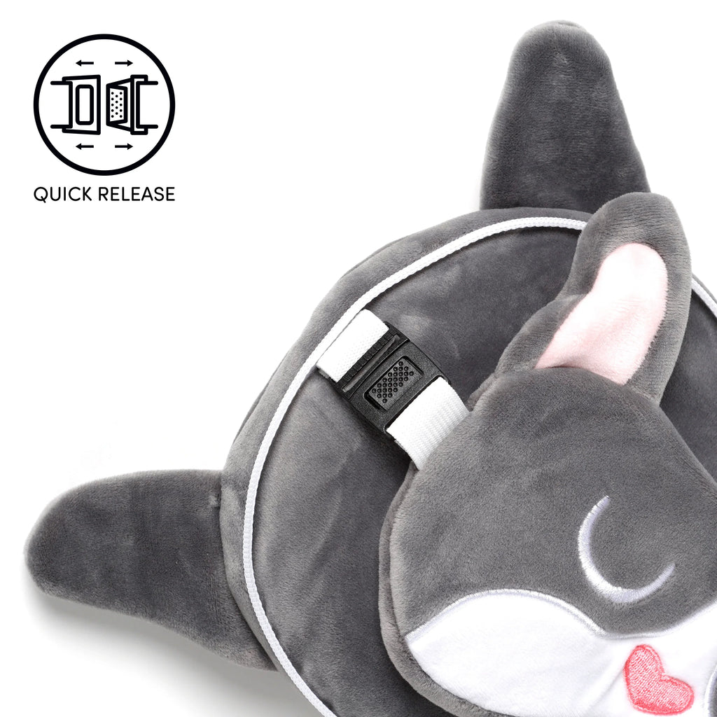 Angled close-up showing a grey plush travel pillow with white piping and a French Bulldog eye mask. The eye mask features pink inner ears, a white muzzle with an embroidered red heart, and is connected to the pillow by a white strap with a black quick-release buckle.