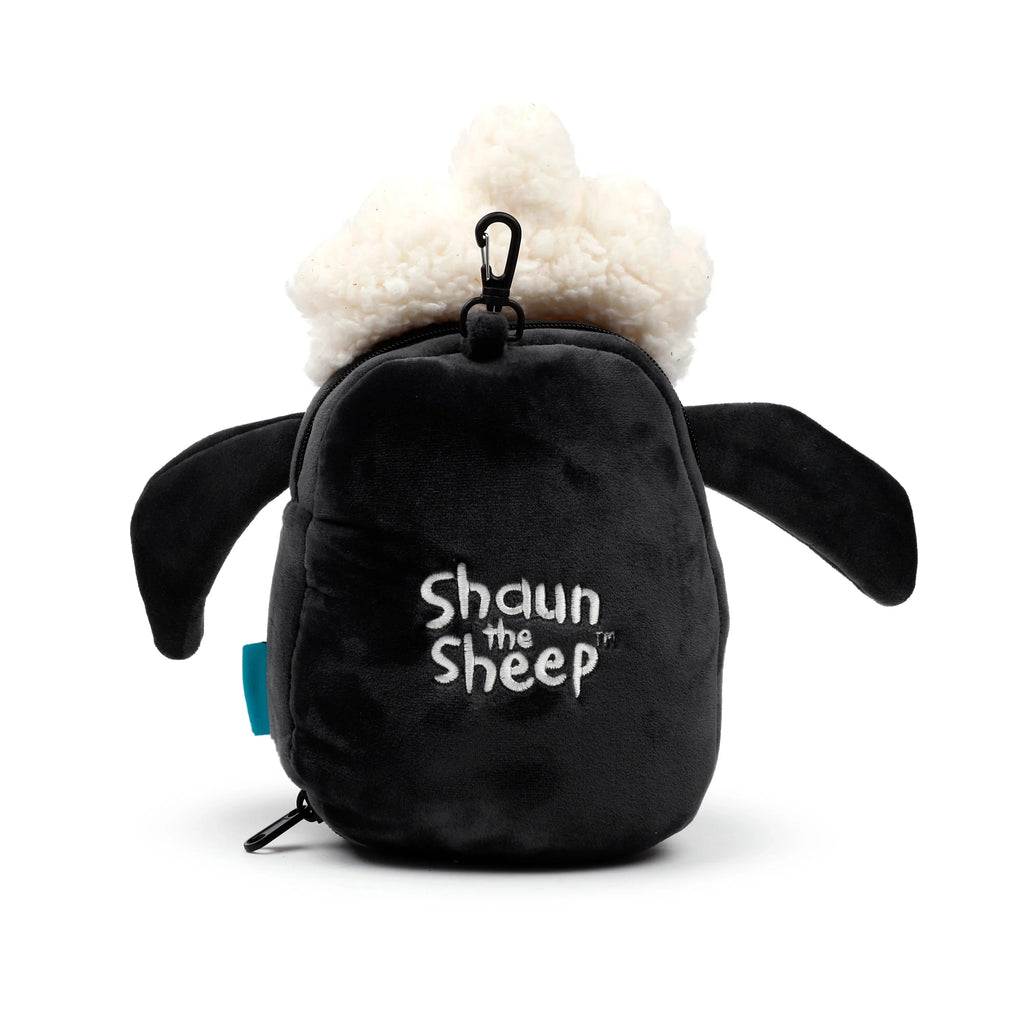 Front view of a Shaun the Sheep travel pillow and eye mask set, depicting the black plush character with a white fluffy top, embroidered 'Shaun the Sheep' text, and a black carabiner clip.
