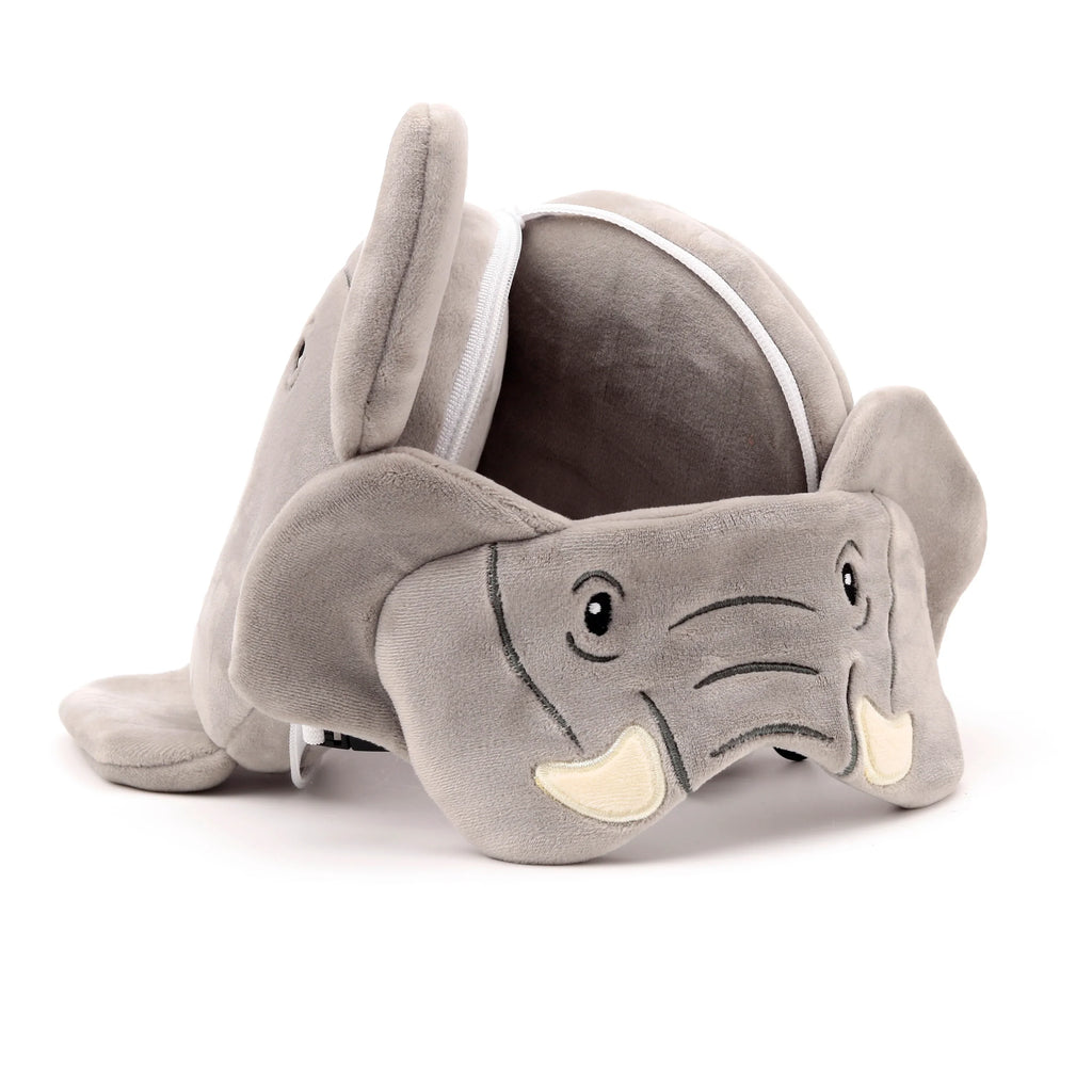Angled view of a grey plush elephant travel pillow, with embroidered eyes, trunk, and tusks, showing an open white zip along its back.