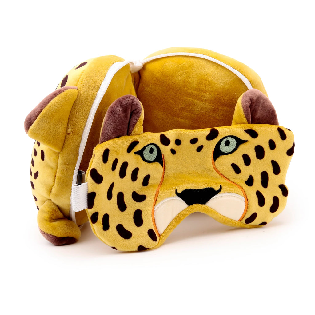 Front view of a plush leopard print eye mask with green eyes and black nose, alongside a matching soft spotted travel pillow with ears, on a white background.