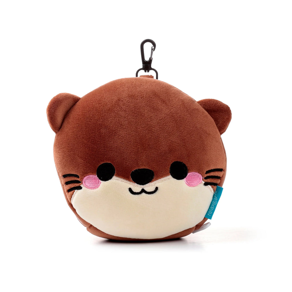 Front view of a brown plush otter travel pillow and eye mask set, featuring embroidered black eyes, nose, mouth, whiskers, and pink cheeks, with a black carabiner clip.