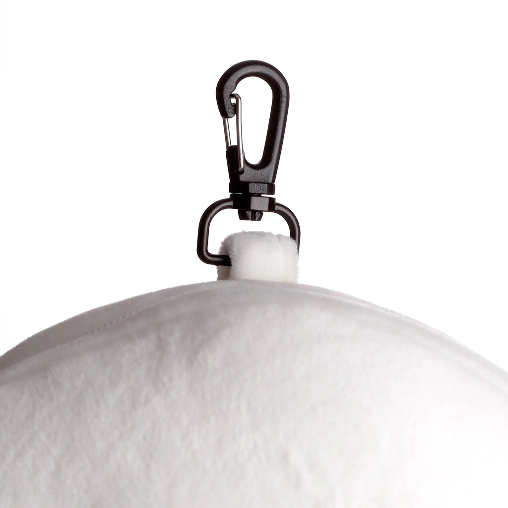 Close-up of a black carabiner clip attached to the white, plush travel pillow.