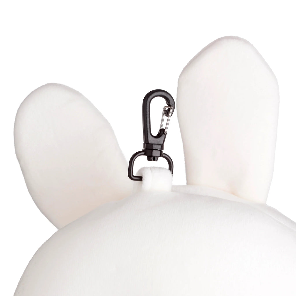 Close-up of a white, fluffy rabbit travel pillow's soft ears and the black carabiner clip attached to the top.