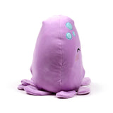 Angled view of a purple plush toy octopus, featuring one embroidered eye, pink blush marks, light blue decorative spots, and fanned-out tentacles.