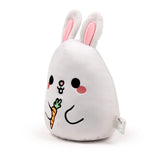Angled view of a white plush bunny toy with pink-lined ears, embroidered black eyes, pink nose, and blush, holding an orange carrot.