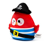 A red pirate plush toy, angled to prominently display its winking eye and black hat with a white skull and crossbones emblem. The toy features an orange beak, a striped body with a black belt and yellow buckle, and a white product tag visible on its right side.