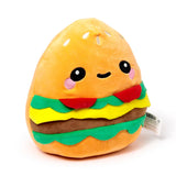 Angled view of a plush hamburger toy with a cute, friendly face, featuring orange buns with white sesame seeds, red, green, yellow, and brown layered fillings.