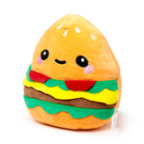 Angled view of a cute burger plush toy, featuring a smiling face with black eyes and pink cheeks on the orange top bun, layered with green lettuce, yellow cheese, and a brown patty.