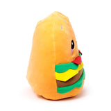 Angled view of a fluffy burger plush toy with an orange-yellow bun, featuring a cartoon eye, pink cheek, and layered brown, green, yellow, and red components.