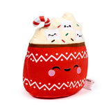 Front view of a red hot chocolate cup plush toy with a white zigzag pattern, featuring embroidered closed eyes with pink cheeks, topped with white whipped cream, three smiling marshmallow faces, colourful sprinkles, and a red and white candy cane.