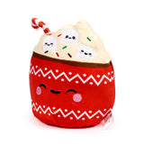 Angled view of a hot chocolate plush toy, featuring a red base with white zigzag pattern, embroidered winking face, cream topping, smiling marshmallow characters, colourful sprinkles, and a striped candy cane.