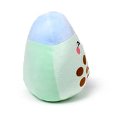 Angled view of a two-tone green and light blue plush toy, shaped like a bubble tea, with a black eye, pink cheek, and brown tapioca spots on its side.