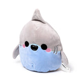 Angled view of a soft, grey and light blue Squidglys Archie the Shark plush toy, featuring a dorsal fin, small side fins, black embroidered eyes, pink cheeks, and a smiling mouth.