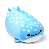 Angled view of a soft, light blue whale shark plush toy with white polka dots, featuring an embroidered smiling face with black eyes and pink cheeks, on a white background.