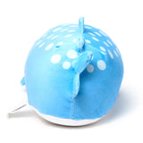 Rounded blue whale shark plush toy, angled rear view showing its back with white spots, a dorsal fin, and a tail fin. The toy has a white underside.