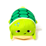 Front view of a green Squidglys Adoramals Altas the Turtle plush toy, with a dark green hexagonal shell, blue spots, black eyes, pink cheeks, and a smile.