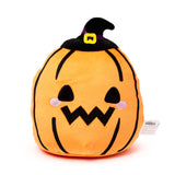 Front view of an orange pumpkin plush toy wearing a black witch's hat with a purple band and yellow buckle. The plush toy has black triangular eyes, a jagged mouth, and pink embroidered cheeks.