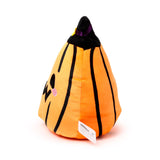 Angled view of a Squidglys orange pumpkin plush toy with black vertical stripes, a black pointed top with purple ribbon and yellow detail, showing one carved eye, a jagged mouth, and a pink cheek.