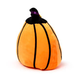 Angled view of an orange plush pumpkin toy with black vertical stripes, a black stem, and a purple ribbon.