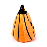 Angled view of an orange Halloween plush pumpkin toy with black stripes, wearing a black witch's hat with a purple ribbon and yellow buckle, showing a partial embroidered face with a black eye and pink cheek.