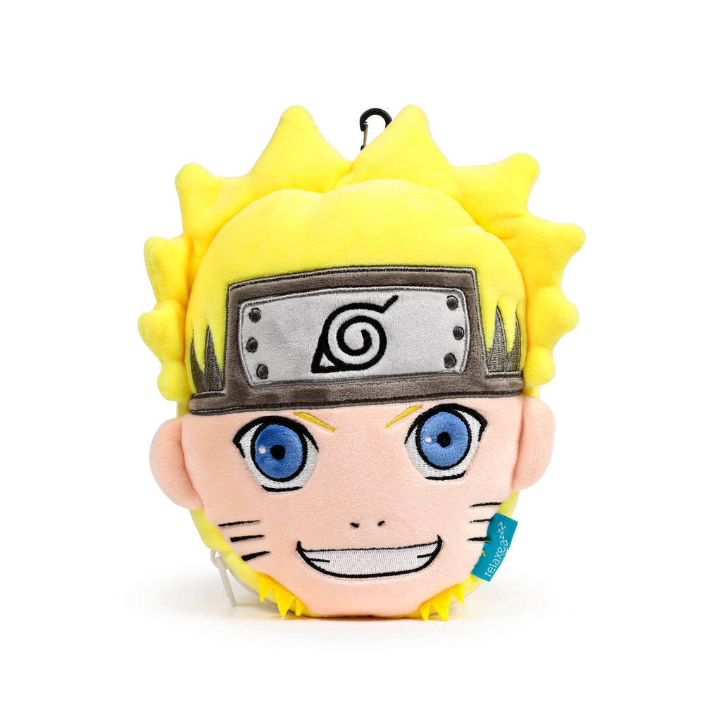 Front view of a plush Relaxeazzz Naruto travel pillow and eye mask, featuring yellow spiky hair, an embroidered grey headband with a black swirl, blue eyes, a smiling mouth, and whiskers. A blue 'relaxeazzz' tag and black carabiner clip are visible.