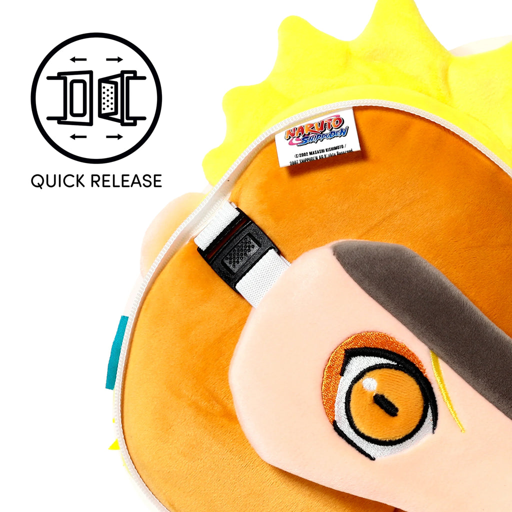 Close-up, angled view of a Naruto travel pillow and eye mask set, showcasing yellow spiky plush hair, an orange fabric base, a white product label, a black quick-release buckle, and an embroidered eye detail on the light peach eye mask.