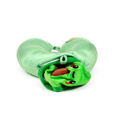 Angled view of a light green plush travel pillow. A darker green avocado-themed plush toy with an embroidered face and a brown 'stone' is partially unzipped and emerging from the pillow.