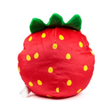 Elidi the Strawberry plush toy, a red soft toy with yellow polka dots and green calyx, seen from an angle with its white care tag visible on the side.