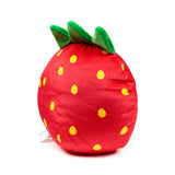 Side view of a red plush strawberry toy, detailed with yellow seeds and green leaves.