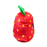 Angled view of a red strawberry plush toy, featuring yellow 'seeds' and a green stalk at the top, with a partial black eye and pink cheek visible on its side.