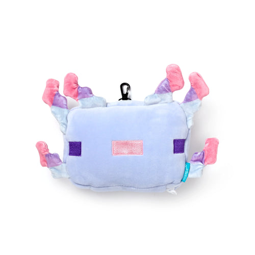 Overhead view of a plush Minecraft Axolotl travel pillow with a pale blue body, pink, purple, and light blue gills, and embroidered pink rectangular mouth and purple square eyes. A black carabiner clip is attached to the top.
