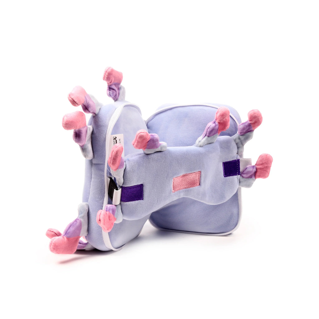 Angled view of a lilac Minecraft Axolotl travel pillow, part of a travel pillow and eye mask set, featuring pink, light purple, and white gills, with dark purple and pink embroidered patches, on a white background.