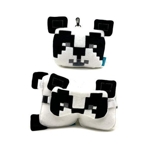 Front view of a compact white and black pixelated panda plush with a black carabiner clip, shown above the unfolded white and black travel neck pillow and integrated eye mask, both featuring pixelated panda details and an adjustable fastening strap.