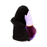 Angled view of a black, dark purple, and lilac-coloured Dracula plush toy, featuring a black cape with an upturned collar, a lilac head, and a thin orange stripe on its dark purple body.