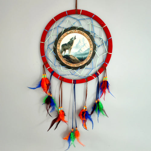 Medium Dreamcatcher with red outer hoop, featuring a central howling wolf illustration against mountains, adorned with colourful feathers and beads.