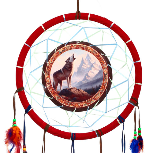 Mountain Wolf dreamcatcher, displaying its vibrant design with a red hoop, central image of a howling grey wolf against snow-capped mountains, internal blue and green webbing, and colourful decorative feathers.