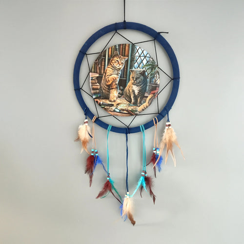 Small dreamcatcher with blue hoop, featuring Purrlock Holmes cat illustration in a library, and dangling multi-coloured feathers with beads, against a light grey wall.