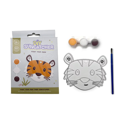 DIY tiger suncatcher kit displayed on a white background, featuring the front of the light blue packaging box with a tiger illustration, an unpainted clear tiger-shaped suncatcher, three pots of paint (orange, white, dark brown), and a blue paint brush.