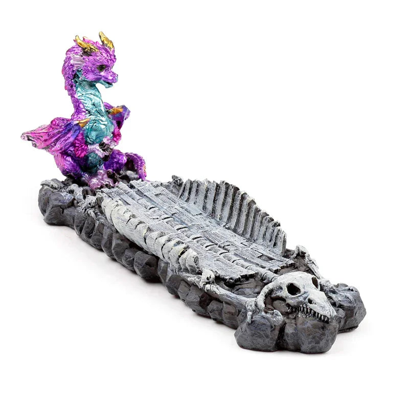 Angled view of a colorful baby dragon incense burner and ashcatcher, featuring a gray dragon skeleton base with a skull at one end.