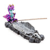 Angled view of an ashcatcher incense burner featuring a vibrant purple, blue, and gold baby dragon figure seated on a grey dragon skeleton base with an incense stick inserted.