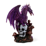 Angled view of an amethyst-coloured purple dragon figurine with an open mouth, perched on a white skull, with brown mushrooms on a mossy base.