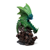 Emerald green dragon figurine with blue accents, perched on a dark, gnarled base with mushrooms, an angled view revealing its scaled body and textured wings.