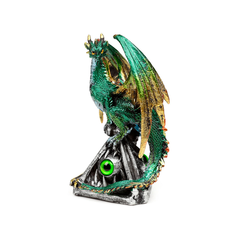 Front-facing view of a dark green dragon figurine with gold-coloured wings and horns and yellow eyes, perched on a grey rock base featuring two prominent bright green emerald eyes.