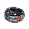 Angled view of a multi-coloured dragon incense burner, featuring a coiled blue, purple, and silver dragon with red eyes and intricate scales, set upon an orange flame-effect base detailed with a Celtic knot.