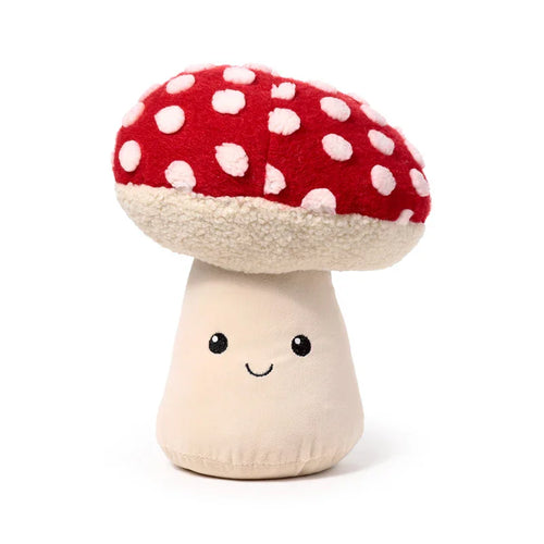 Plush mushroom door stop, front view, with a red and white spotted cap, cream textured underside, and a cream stem featuring an embroidered smiley face.
